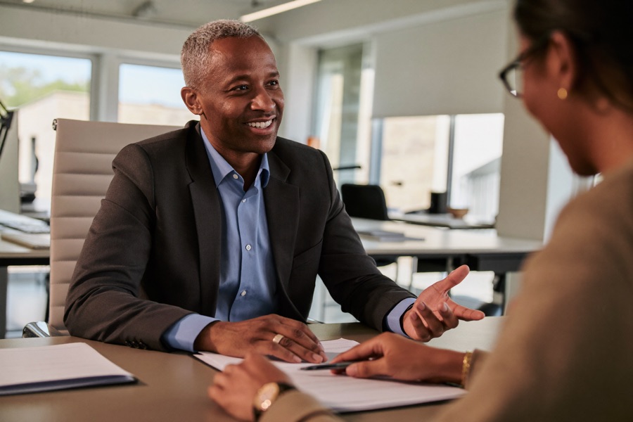 An advisor walking a client through paperwork across a desk