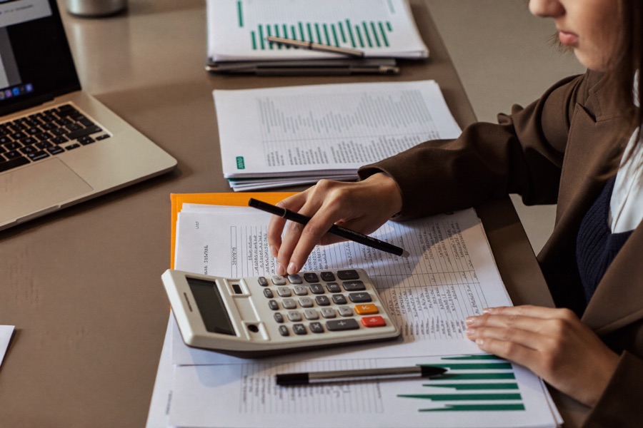 An accountant working through tax documents with a calculator